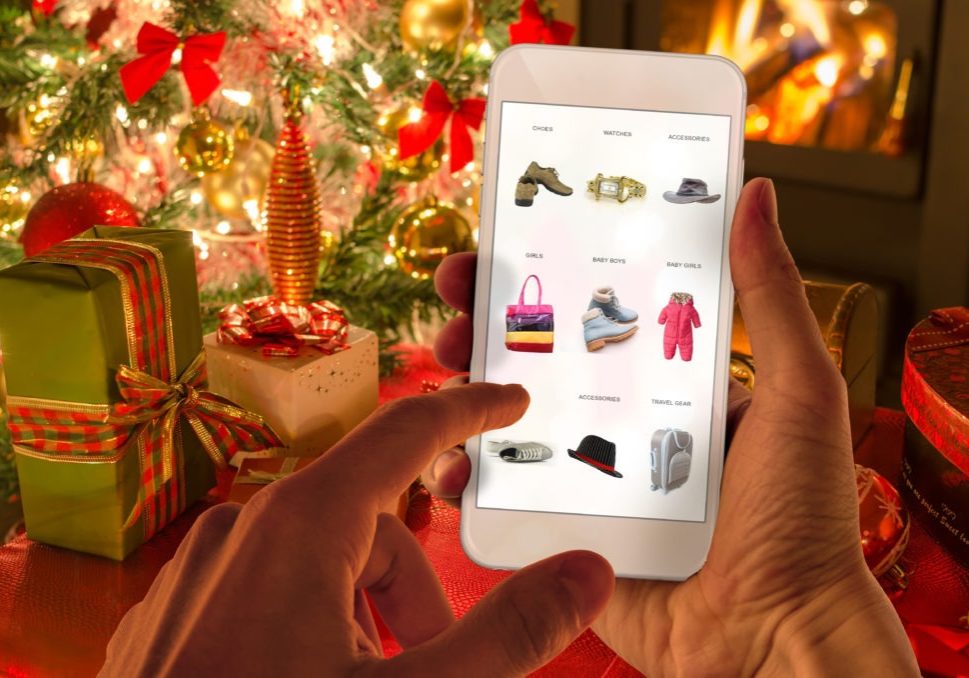 Christmas online shopping with phone. Christmas tree, gifts, lights and decorations.
